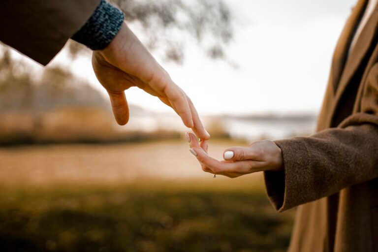 An image of a man and woman holding hands in a field, representing trust and unity. Find comfort and empowerment through Bible verses on trust in relationships.