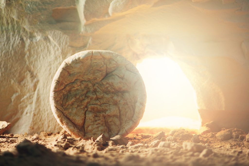 Stone is rolled away from empty grave on Easter morning. He is not dead, He is Risen concept.