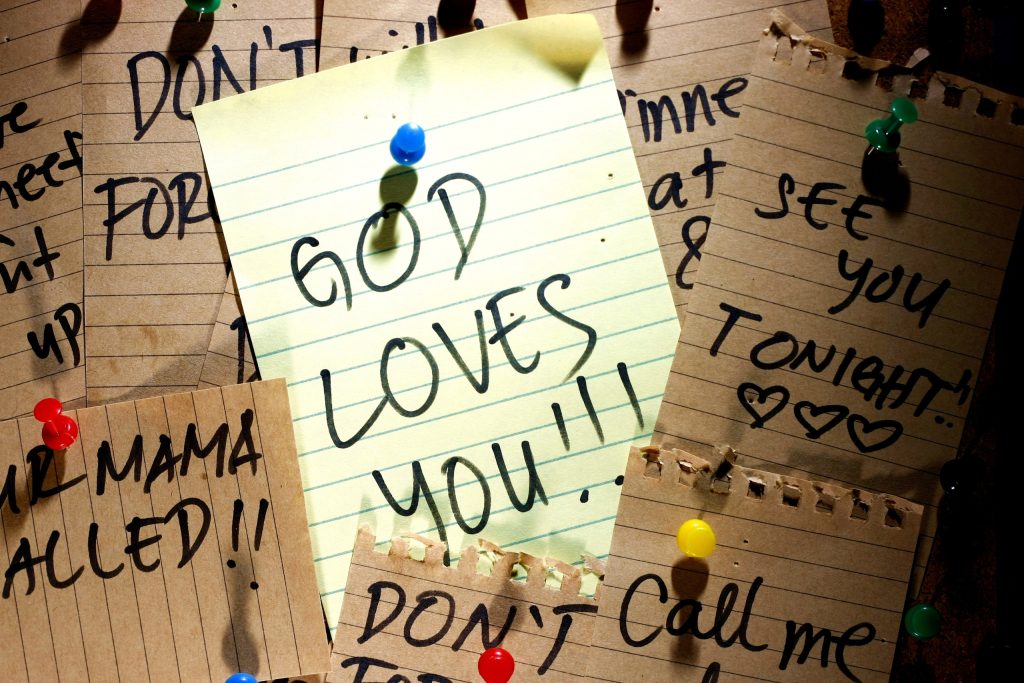 A pinned note paper featuring the phrase, “God's Love,” conveying a heartfelt message of God's love.