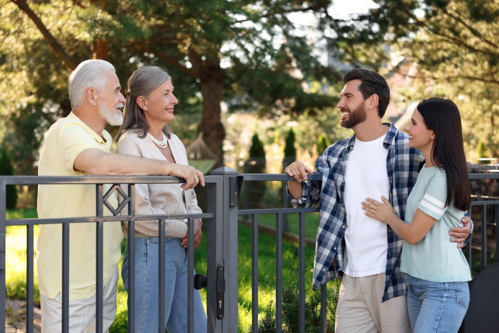 Four neighbors chatting while standing in a fence, symbolizing love for neighbors.