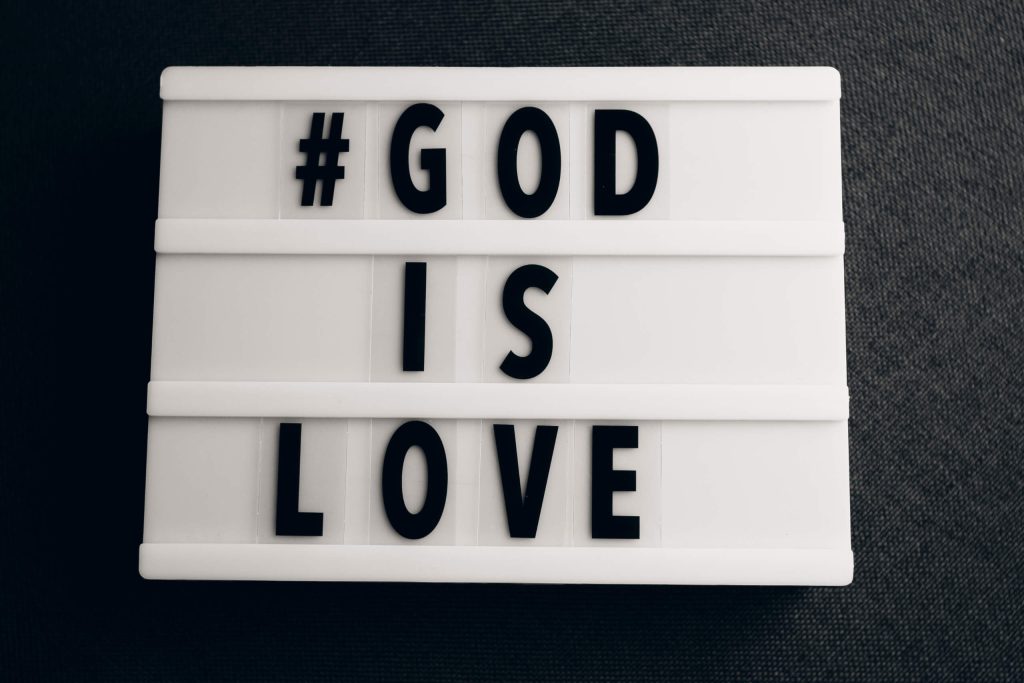 Conceptual image depicting the phrase “God is Love” with an artistic element symbolizing love.