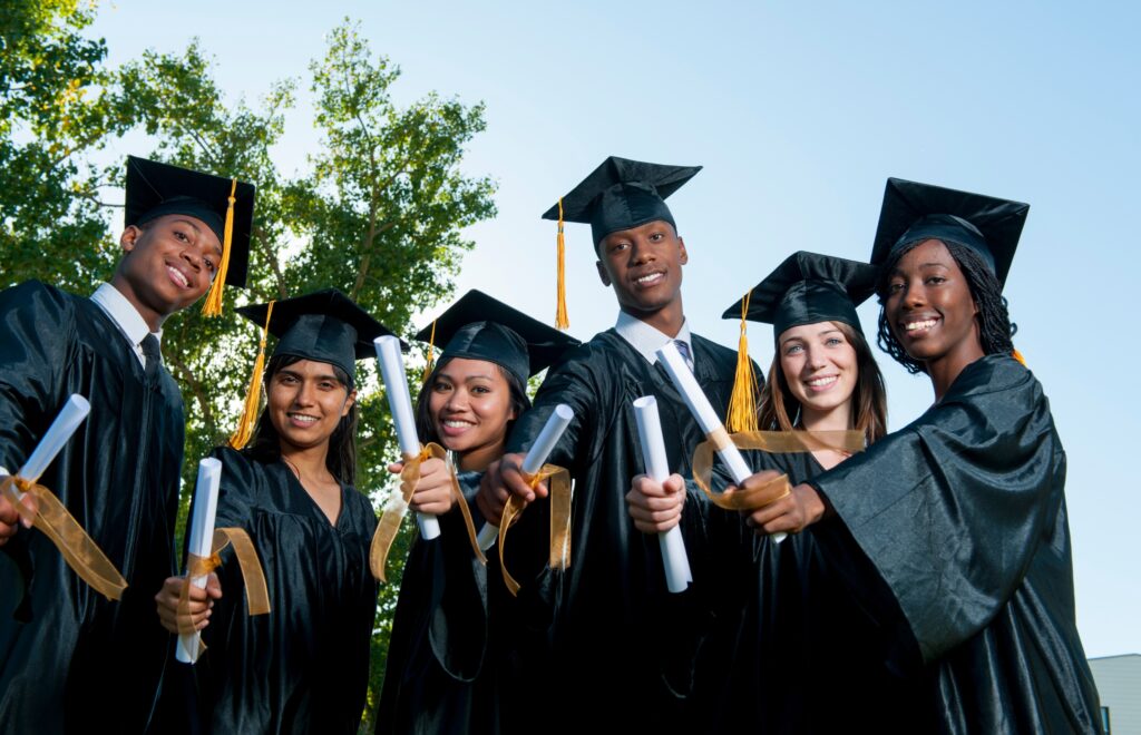 A celebratory group of graduates in gowns, each holding their diploma, representing their hard-earned accomplishments.